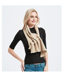 Detail view of beige knit scarf showing its unique multi-layered interlocking loop design