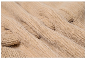 Close-up detail of soft camel hollow-out knit scarf showing rich texture and warmth