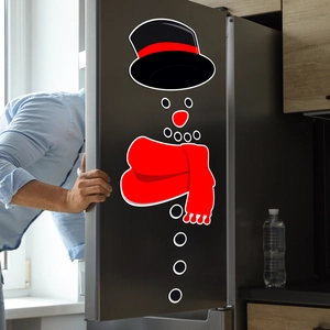 Close-up of DIY snowman magnetic stickers with red scarf on a black refrigerator