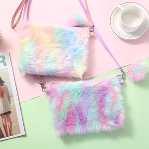 Close-up of rainbow plush crossbody bags with soft faux fur texture and pompom detail