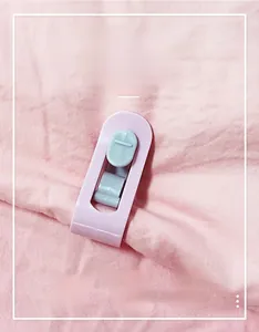 Pink and blue needle-free quilt clips securing bedding fabric with a secure snap closure