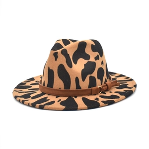 Dettaglio del cappello fedora con stampa mucca e cinturino in pelle marrone e oro
