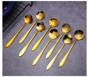 Detailed macro view of 8 golden stainless steel spoons with unique floral patterns