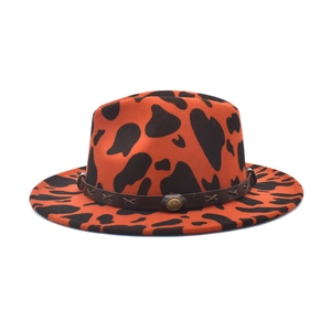 Close-up of orange cow print wool fedora with brown leather band and retro metal buckle