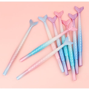 Close-up of cute gradient pink and purple mermaid fin gel pens on pink background