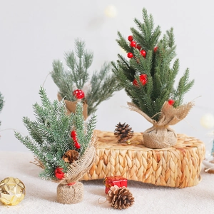 Mini sapins de Noël avec pommes de pin et baies rouges sur socle en toile de jute
