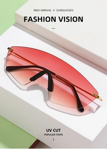 Detail of red and black gradient oversized sunglasses lens with UV protection and gold trim