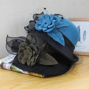 Detail of wool felt cloche hat with floral mesh veil and elegant rolled brim decoration
