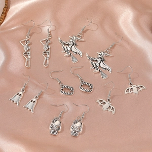 Halloween earring set with vintage silver skull, ghost, and witch designs on pink silk