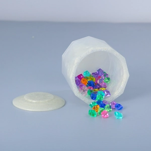 Detailed macro of octagonal resin storage jar with silver glitter rim and colorful crystals