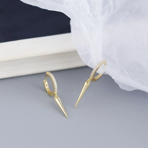 Detail of gold hoop earrings with sparkling zircon pave and polished spike pendants