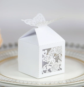 Macro detail of laser-cut ivory butterfly favor box with intricate floral patterns