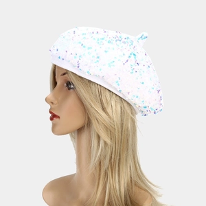 Detail of white beret featuring iridescent sequins reflecting blue and pink light