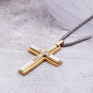 Detail of two-tone gold and silver cross pendant necklace with inset rhinestones
