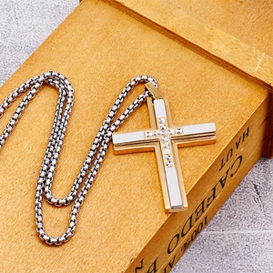 Detail of two-tone gold and silver cross pendant with textured center on box chain