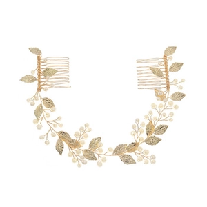 Detailed shot of bridal hair comb with gold metal leaves and white pearls for weddings