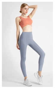 Détail du legging de yoga taille haute et du débardeur de sport court orange assorti