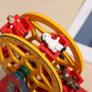 Détail d'une grande roue musicale en bois avec des figurines et un petit ours