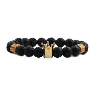 Beaded bracelet for men with matte lava stones and a golden crown pendant on white background
