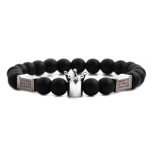 Detail view of black matte beads and silver crown charm on elastic men's bracelet