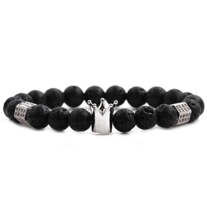 Macro shot of black volcanic stone beads with a silver crown charm and metal spacers