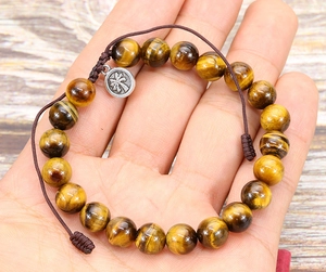 Detail of tiger eye bead bracelet with adjustable cord and palm tree charm