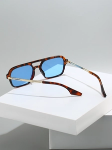 Detail of tortoise shell frame pilot sunglasses with vibrant blue lenses and gold temples