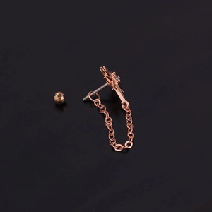 Detail showing rose gold star earring with cross pendant and crystal chain link