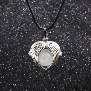 Macro shot of silver heart pendant with white bead on black wax cord necklace