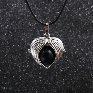 Detail view of heart pendant with silver wings and black bead on necklace cord