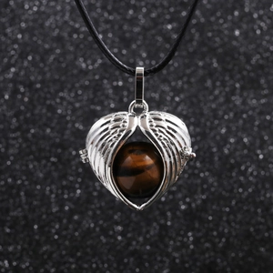 Macro detail of angel wing pendant with tiger eye stone on black cord necklace