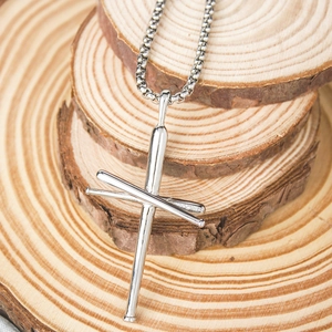 Macro view of silver cross necklace made of baseball bats on a natural wood background