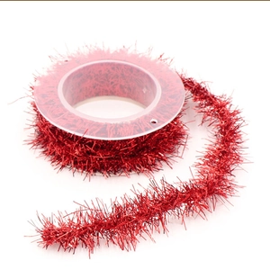 Detail of red tinsel garland ribbon roll for Christmas gift wrapping and holiday decor
