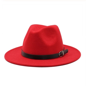 Détail du chapeau en feutre rouge avec une bande en cuir noir et une boucle en métal argenté