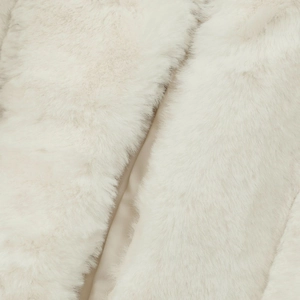 Close-up of soft cream faux fur jacket texture with plush fibers and premium lining