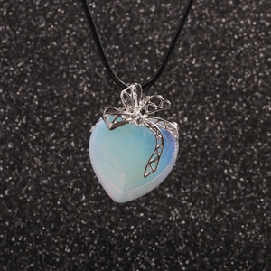 Collier en cordon avec pendentif cœur opale et nœud argenté sur fond scintillant