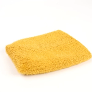 Macro shot of fluffy bright yellow faux fur fabric with golden glitter yarn detail
