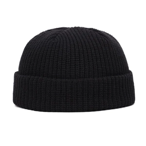 Macro shot of black knitted beanie texture with detailed ribbed winter wool pattern