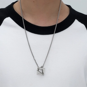 Unisex silver geometric cube pendant necklace in polished titanium steel on model