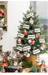 Detail of Christmas snowman welcome sign hanging on a decorated festive pine tree