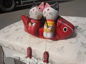 Detailed view of hand-painted wooden cat figurines on a fish base for home decor