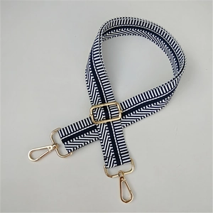 Detail of adjustable blue and white striped bag strap with gold metal swivel hooks