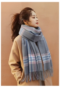 Détail d'une écharpe douce effet cachemire à carreaux gris rose bleu avec des franges