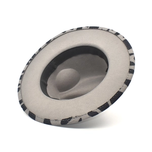 Detailed view of the grey felt fedora brim with black and white cow print fabric edging