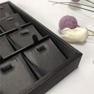 Detail view of a 24-slot black brushed jewelry tray for necklaces and pendant displays