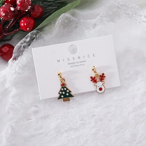 Detail of Christmas earrings with enamel tree and reindeer designs on a 925 silver post