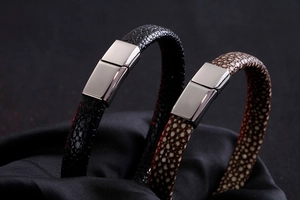 Macro detail of black and brown stingray leather bracelets with polished steel clasps