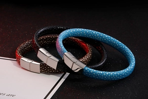 Close-up of stingray leather bracelets in blue, black, and brown with steel clasps