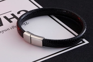 Detail of black textured leather bracelet with a magnetic silver metal clasp closure
