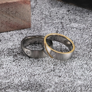 Brushed stainless steel couple rings with single zircon inlay in silver and gold tones
